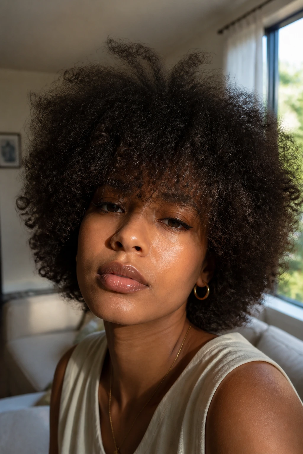 Person with blown-out voluminous fringe in sunlit room