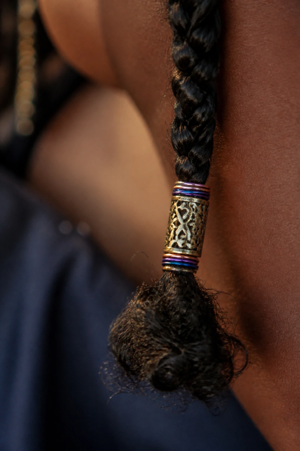 Braid end with ornate metal cuff and decorative wire.