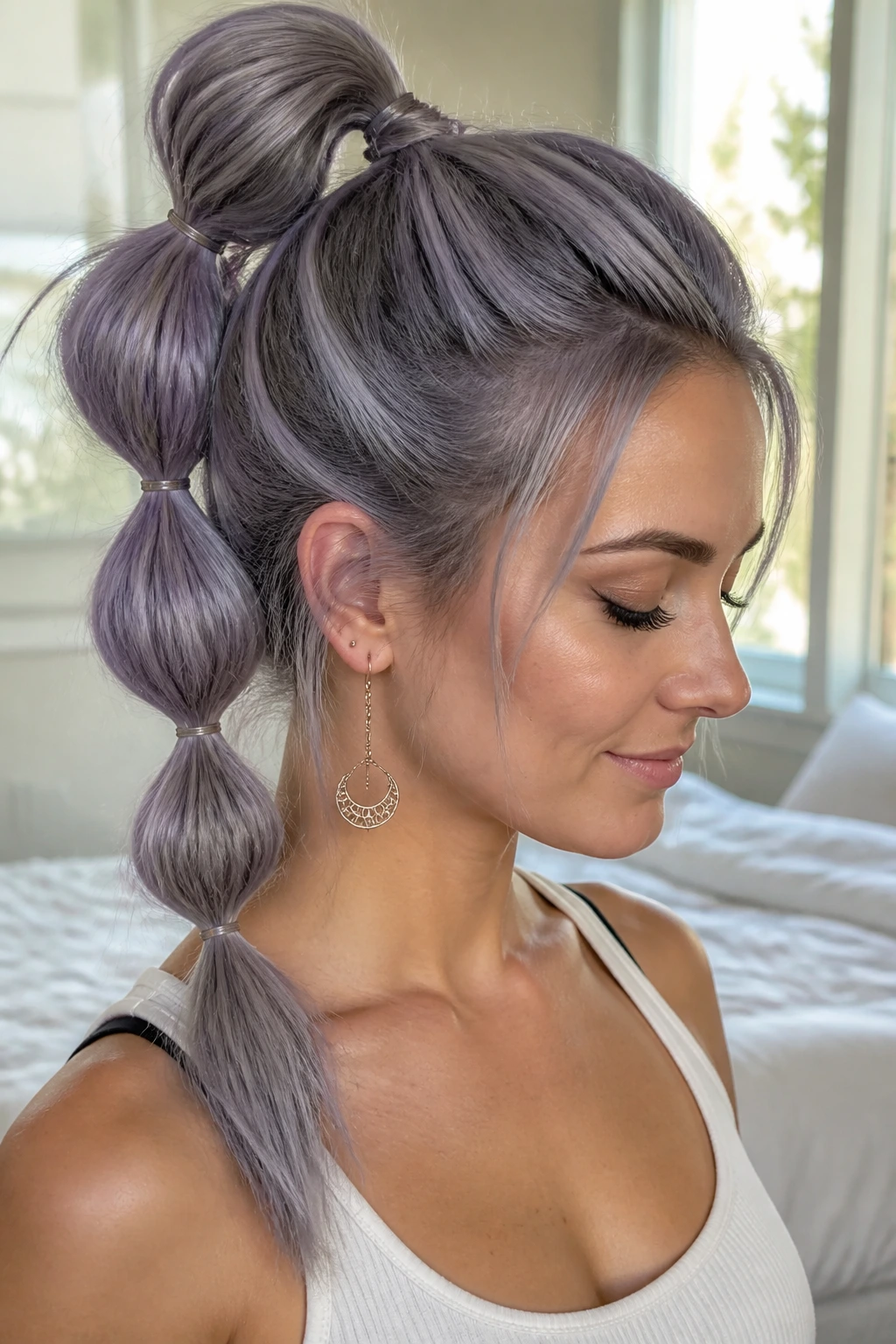 Close up of a real woman with violet gray bubble ponytail in soft window light
