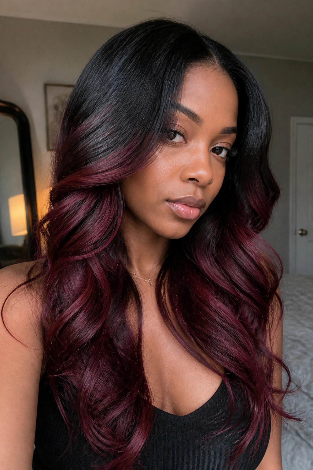 Portrait of a real person with black roots fading to burgundy ends.