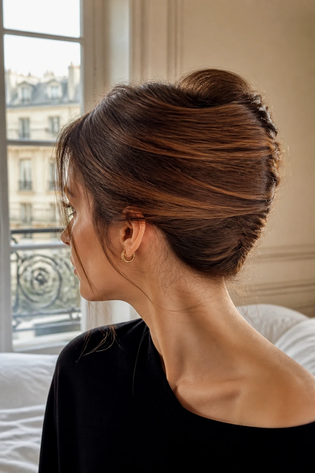 Close-up of a real woman wearing The Classic French Twist with temple wisps