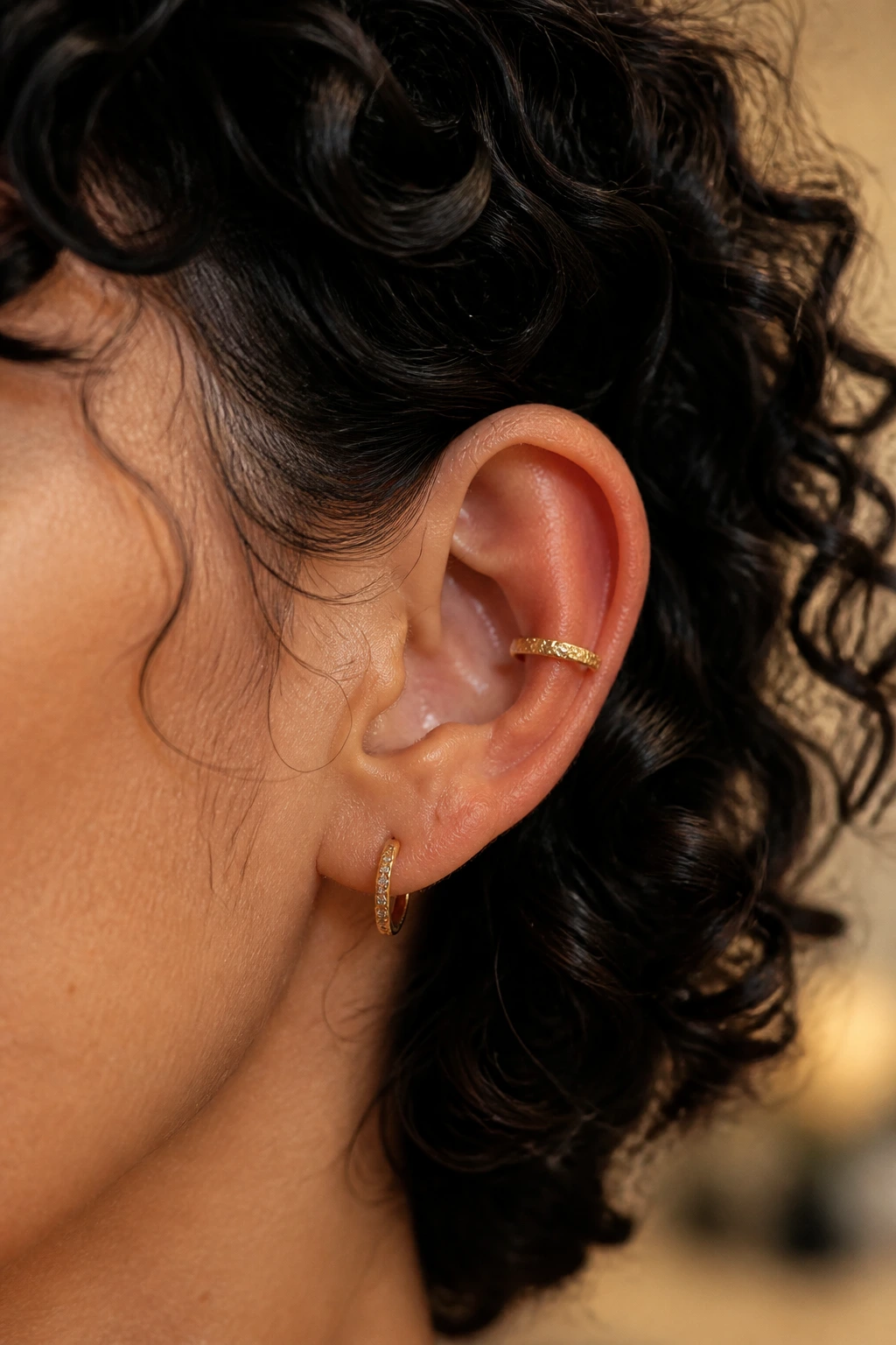 Close-up of textured concha cuff on ear with curls