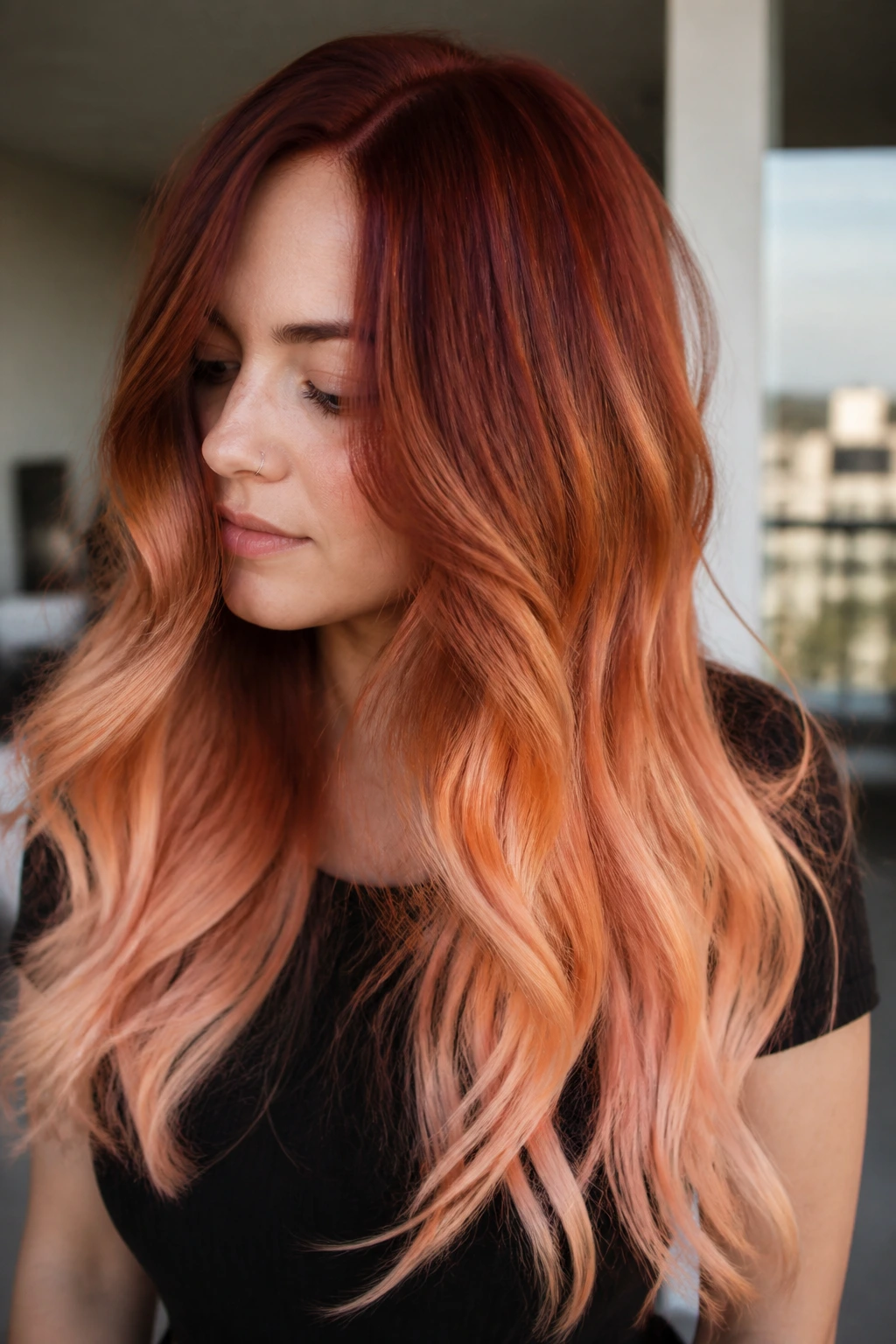 Close-up portrait of a real person with copper mahogany to peach sorbet melt; thick hair framing the face in balcony light