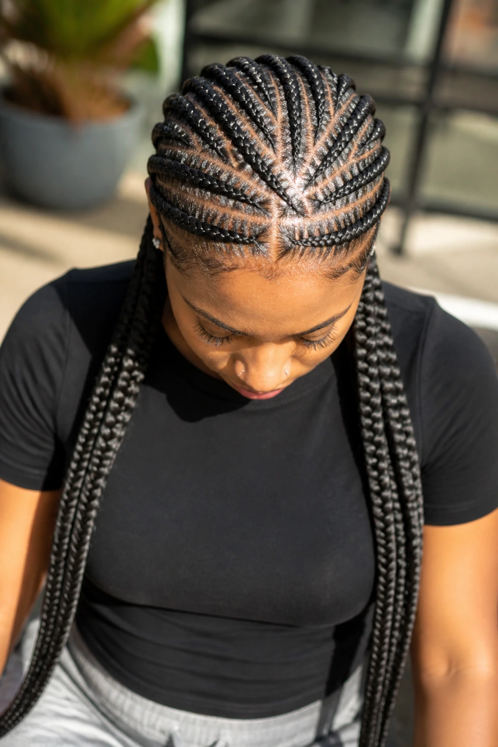 Real person with crisscross cornrows and long braided tails at crown