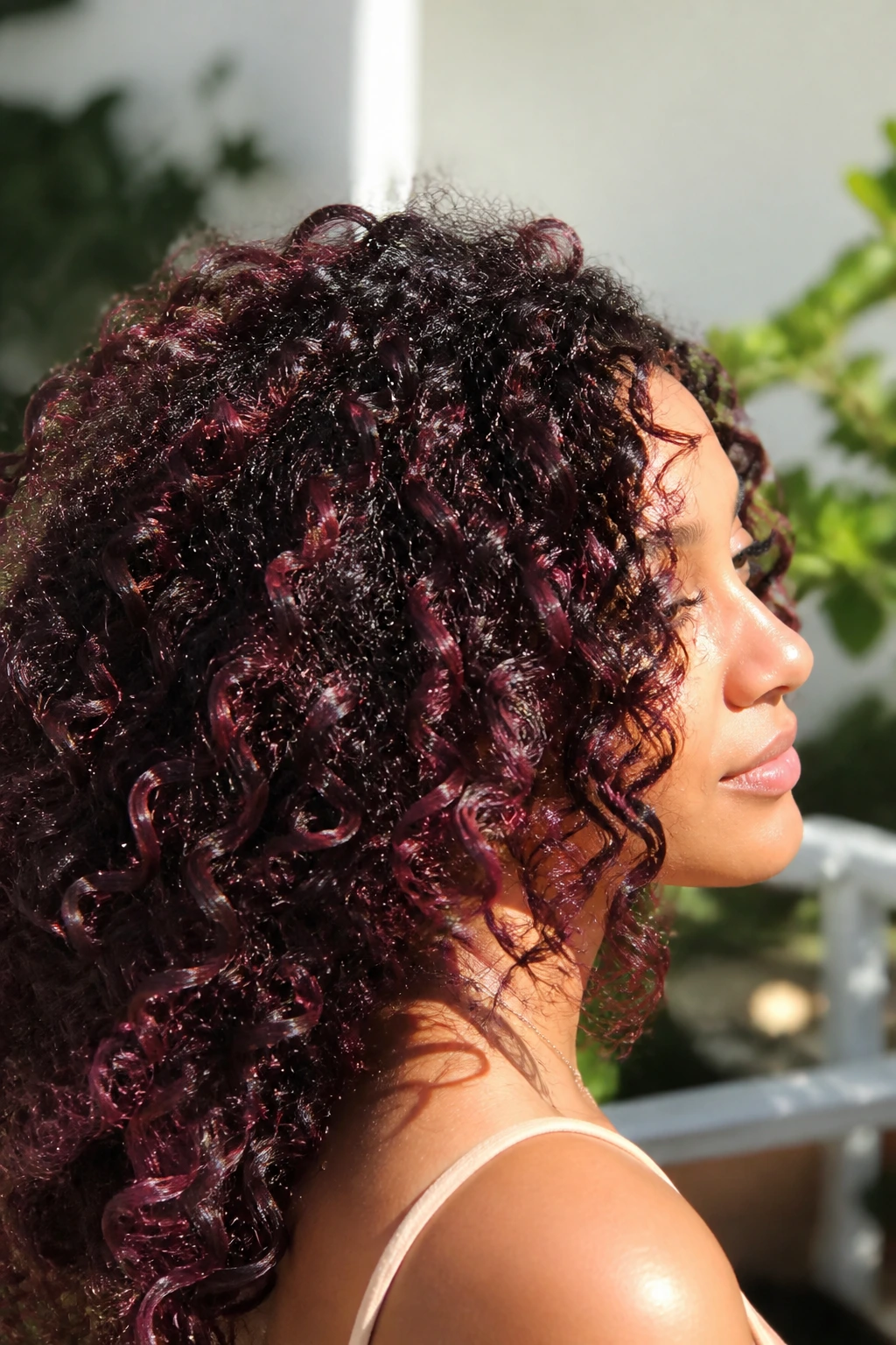 Close-up portrait with cherry cola deep red streaks in curly hair