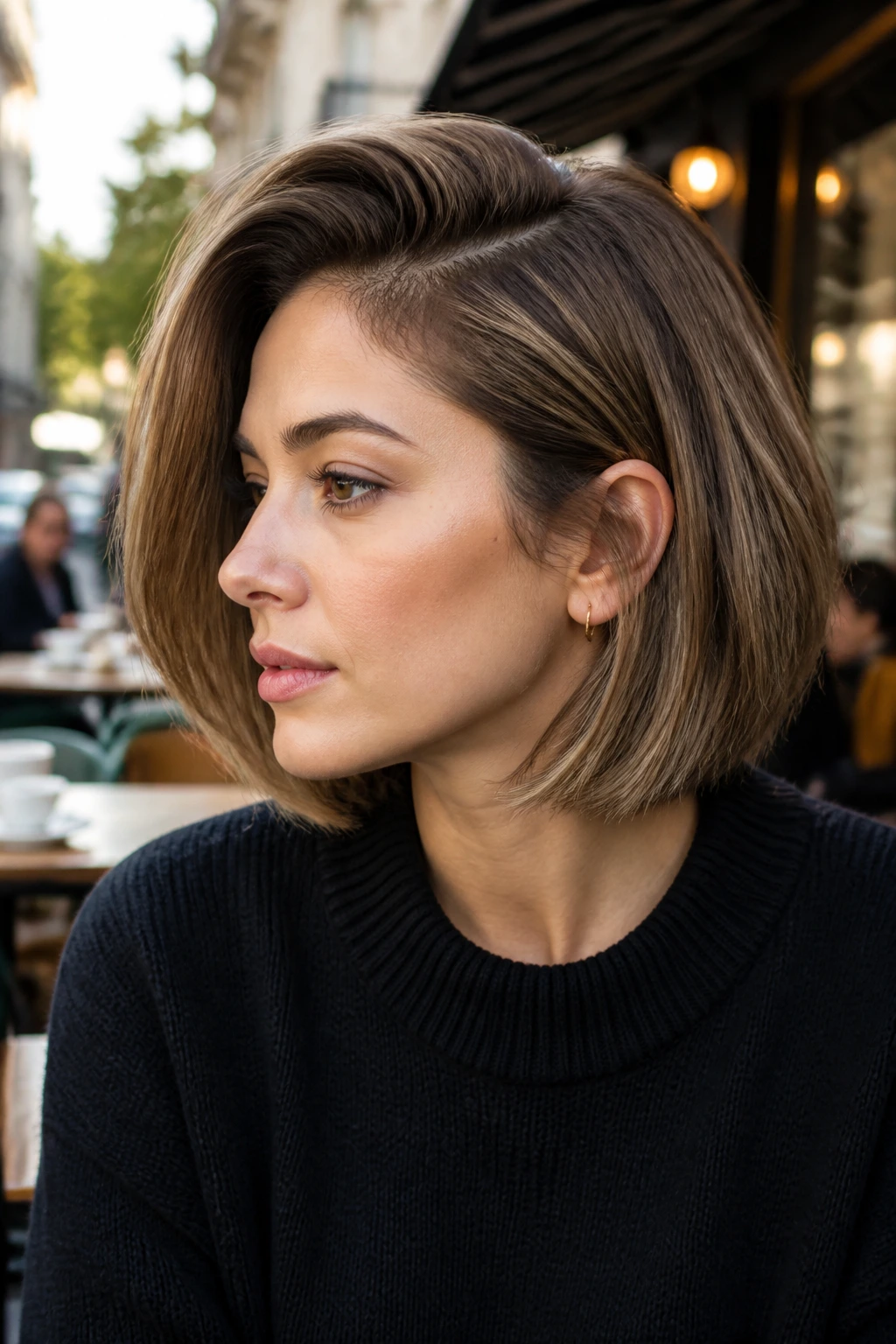 Close-up portrait of a real person with a deep side-parted bob.