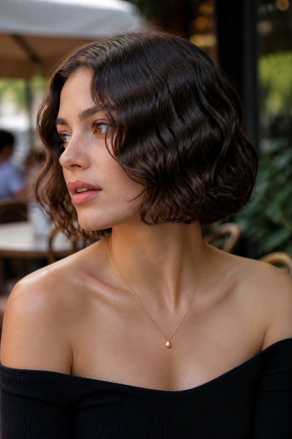 Close-up of a short bob with deep mermaid waves on a real person in soft outdoor light.
