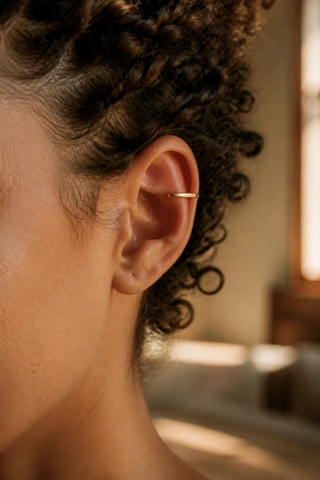Close-up of a sleek metal ear cuff on the ear cartilage of a real person