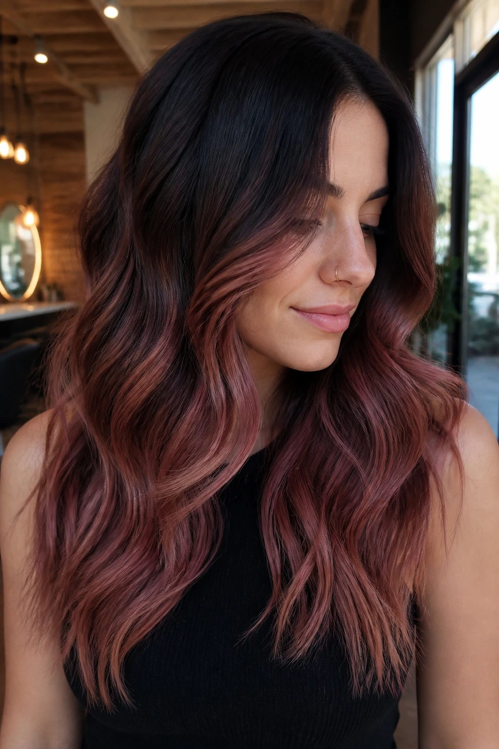 Close-up portrait of hair color melt from espresso to rosewood brown on a real person, moody salon setting.