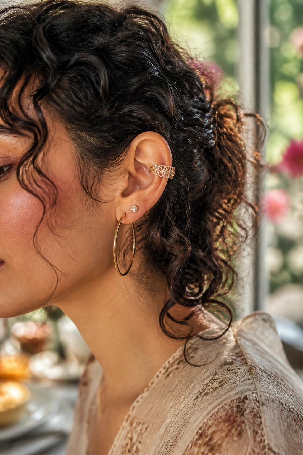 Close-up of ear with filigree lace cuff in soft garden light