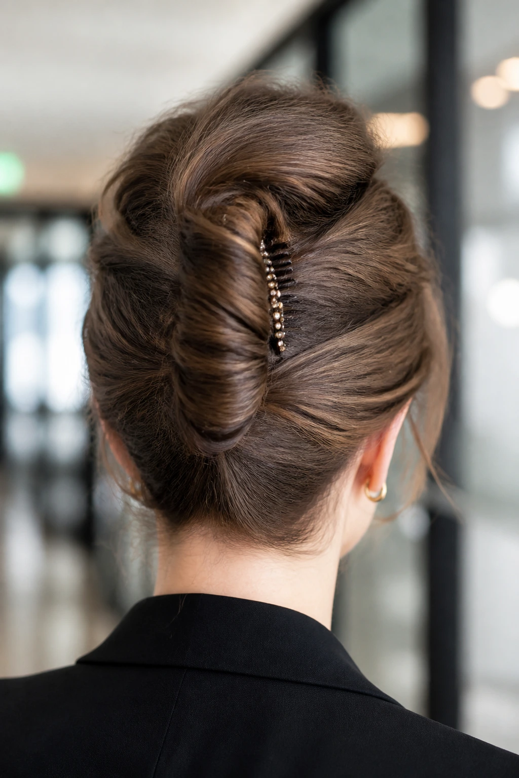 Back view of a woman with a French twist secured with pins in an office