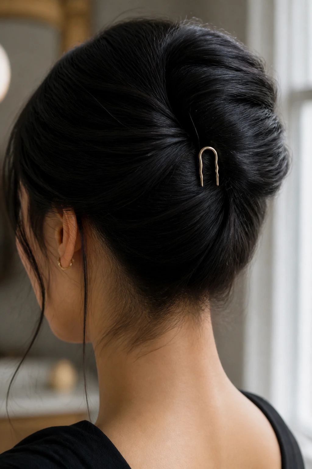 Close-up portrait of a real woman wearing a French twist secured with a U-pin