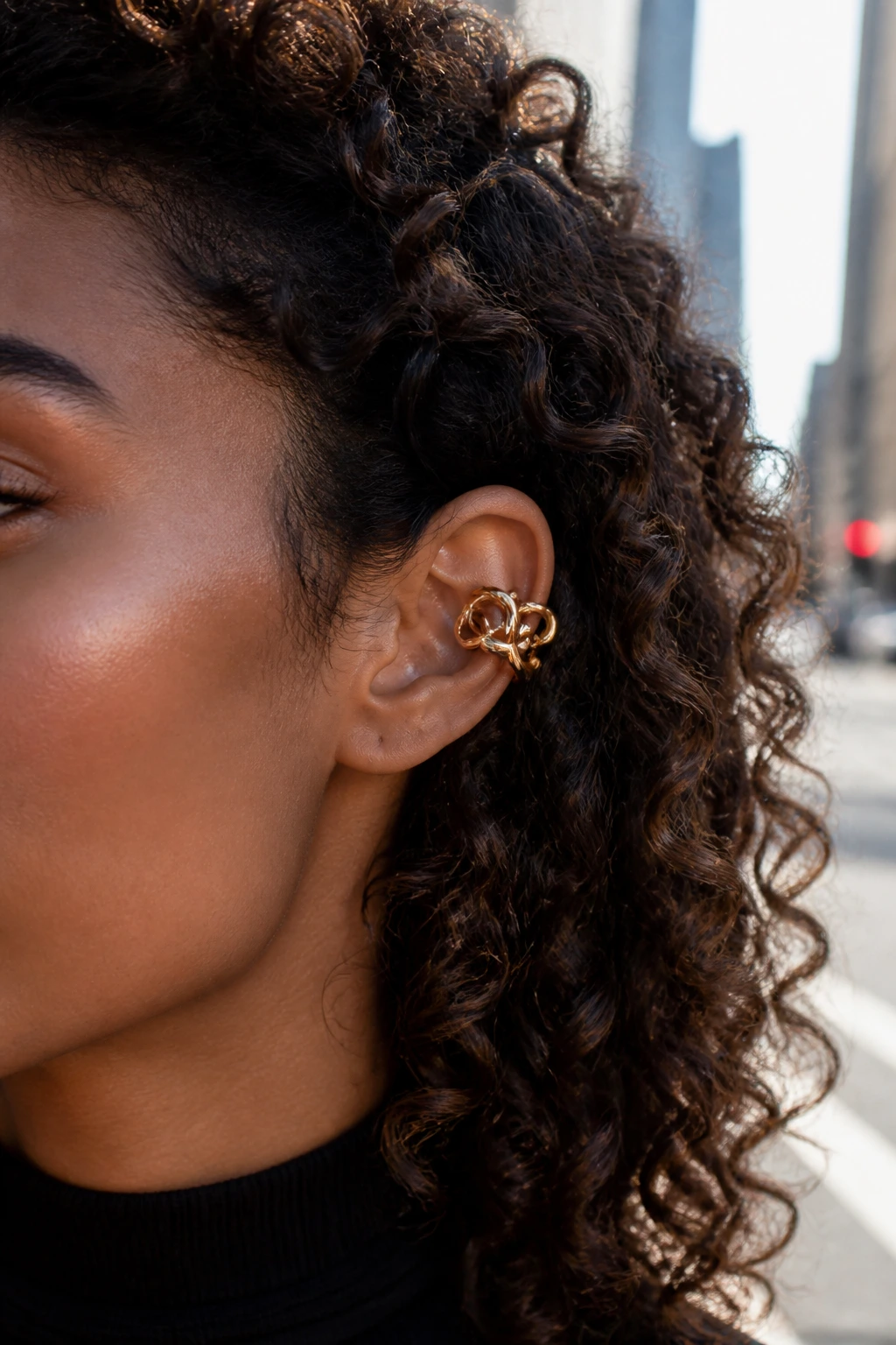 Close-up of geometric hoop stack ear cuff on real person with curly hair