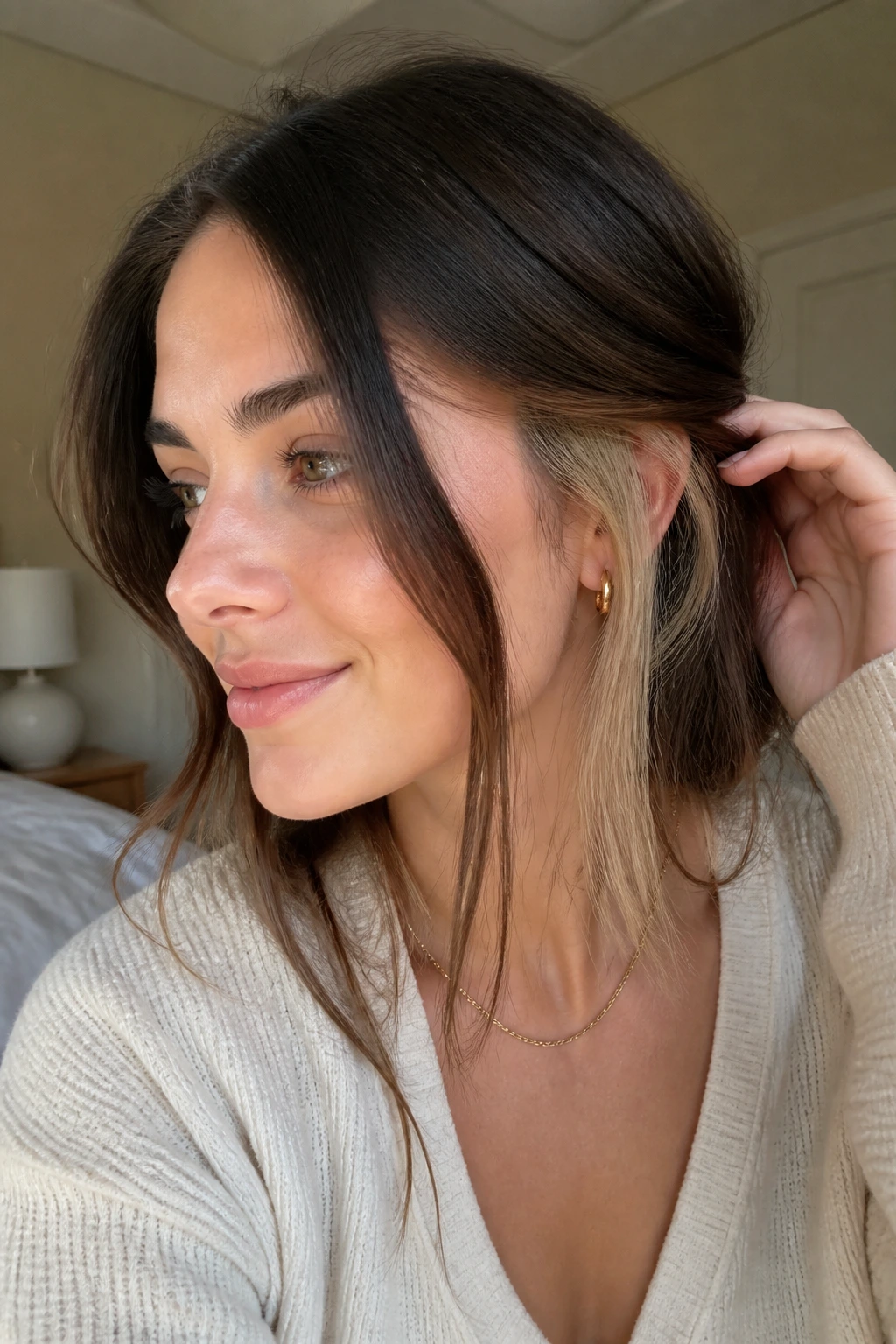 Close-up of a real woman showing a hidden blonde mid-layer under brunette top layer.