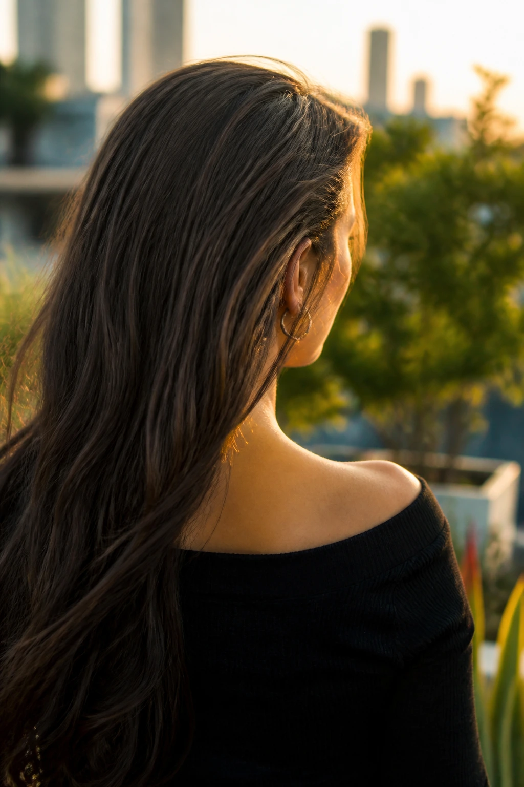 Rear three-quarter view of a real person with long hair covering the nape, highlighting the hidden undercut.