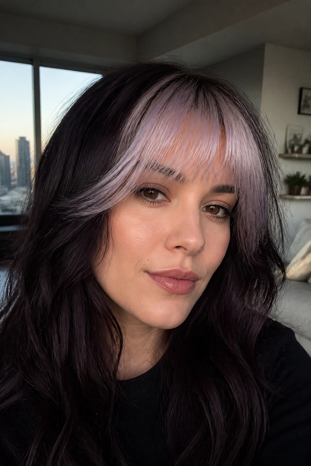 Close-up portrait of a woman with plum-black hair and lilac-blonde feathered fringe.