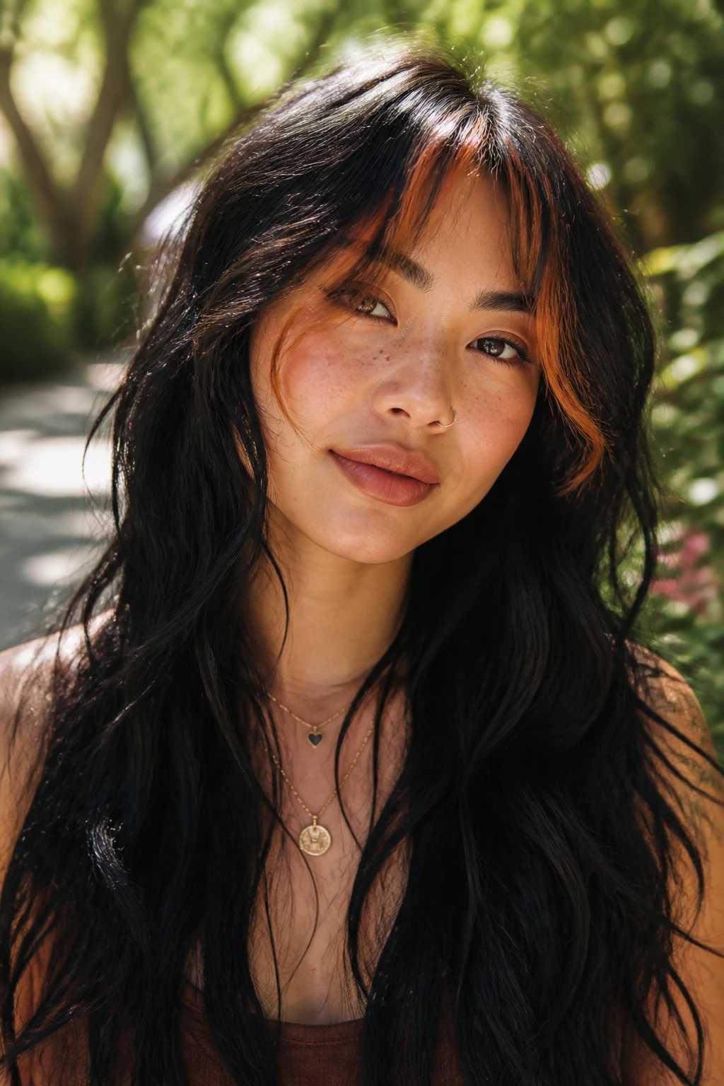Close-up of a real person with long jet-black waves and wispy ginger wisps