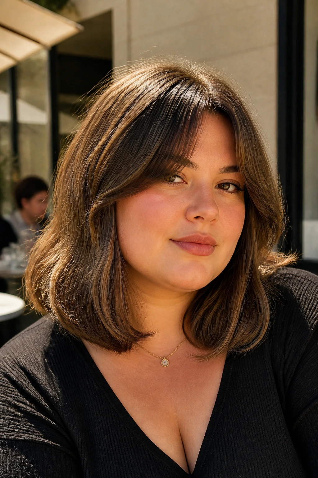 Close-up of a woman with lob and curtain bangs at an outdoor cafe