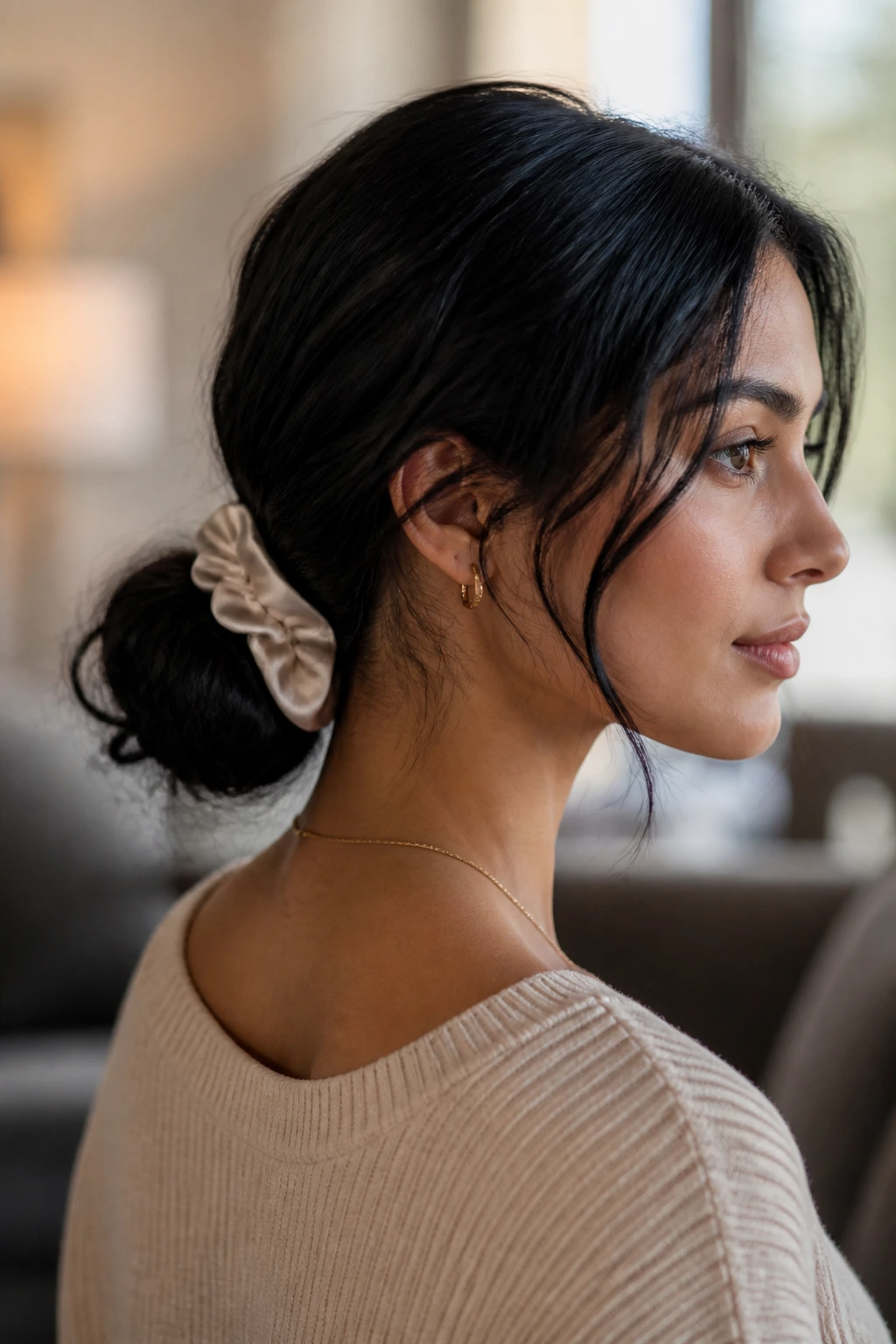 Close-up of woman with textured low bun and silk scrunchie in black hair