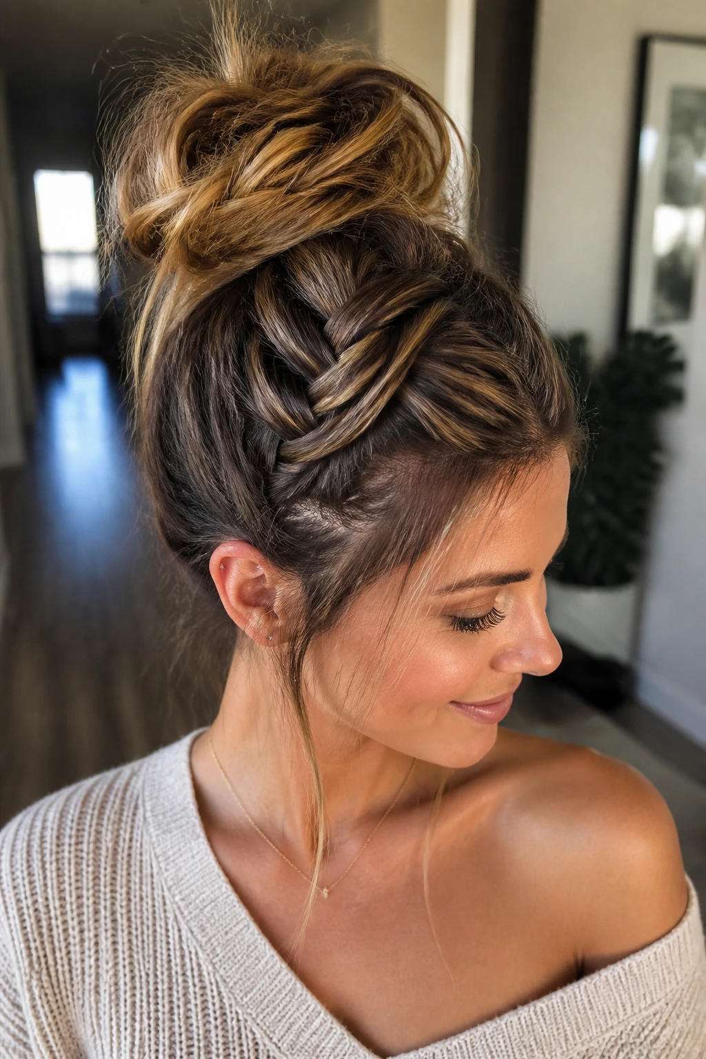 Real woman with French braid flowing into a messy topknot