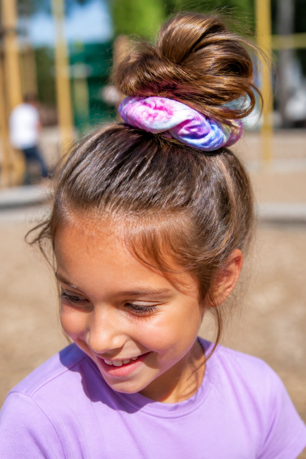 Child with a high messy bun secured by a colorful scrunchie