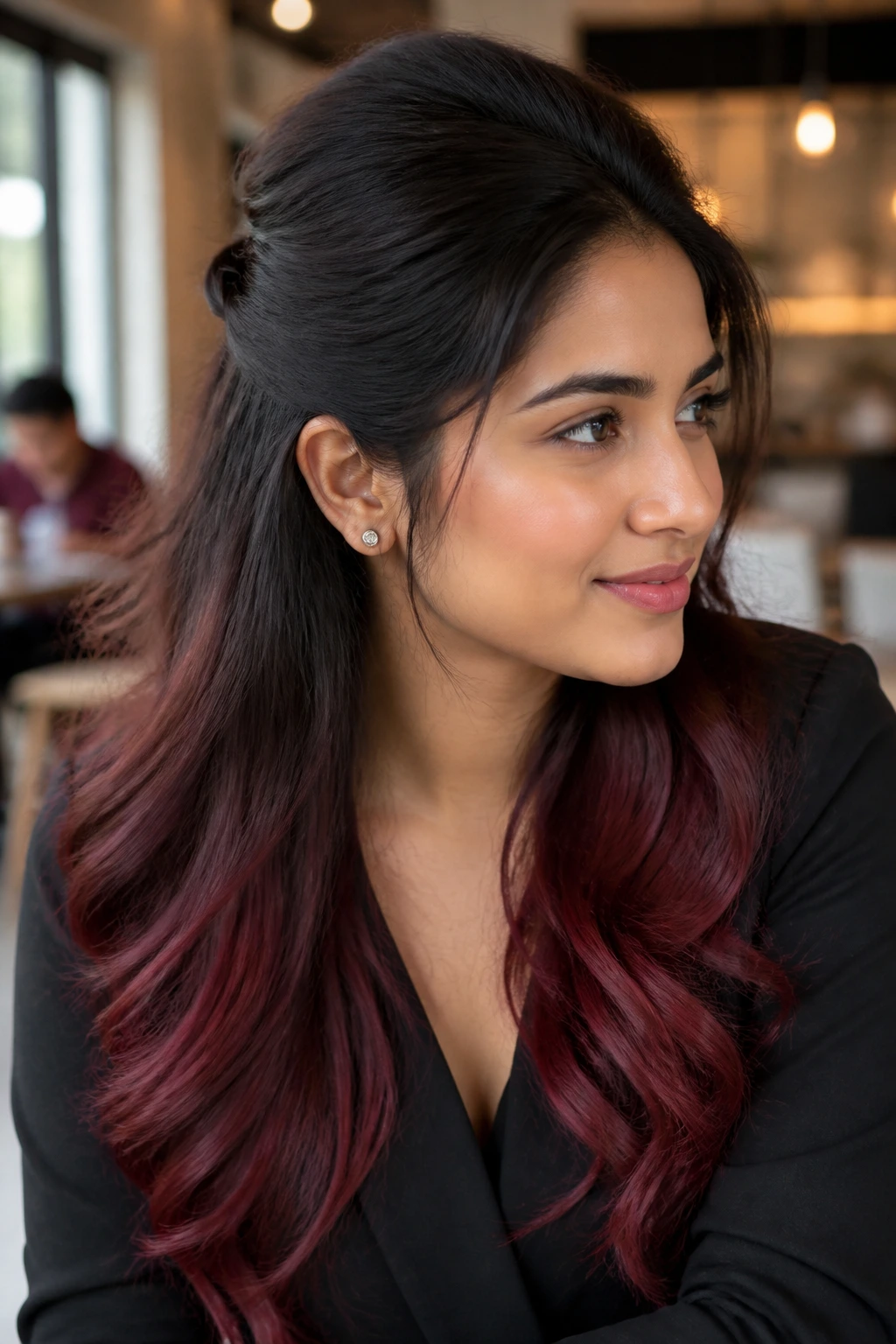 Portrait of a person with dark roots and maroon ombré ends in an office setting