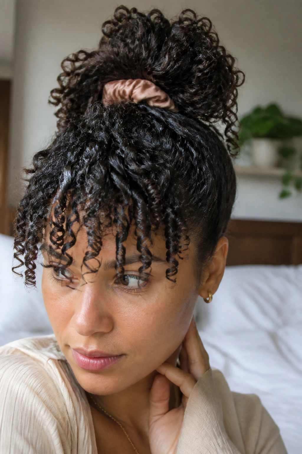 Close-up of a real woman with a loose pineapple-tied top loop for curly hair