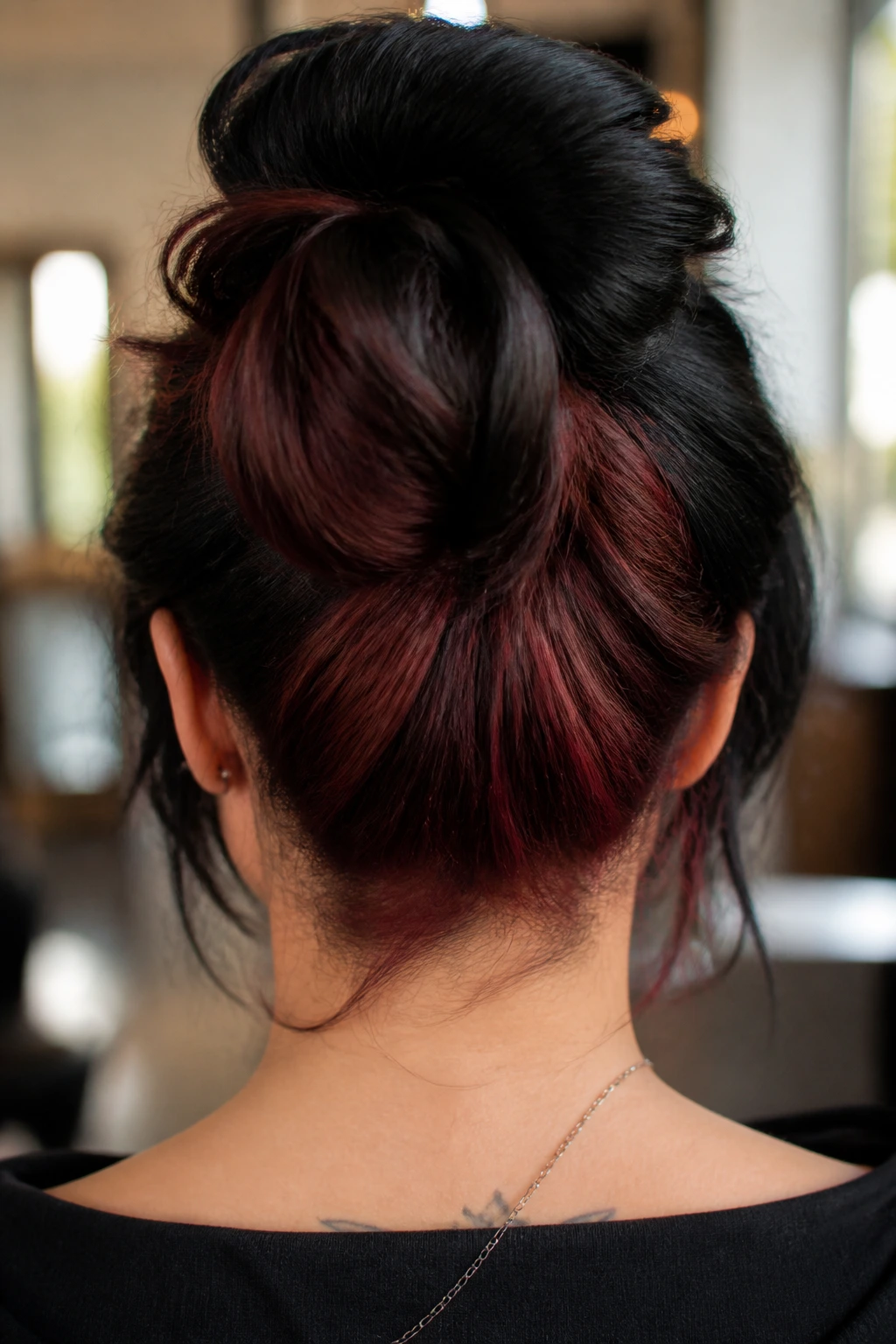 Close-up rear view of thick hair with mahogany red undertones on jet-black base