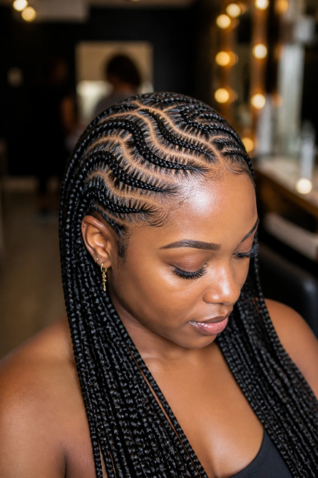 Real person with zig-zag curved parting lines in Ghana braids showing scalp coverage.