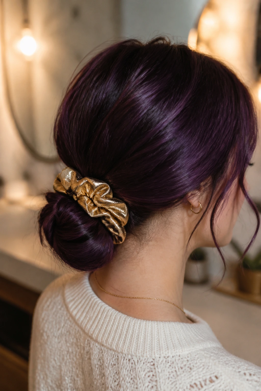 Close-up of dark purple hair in a low chignon with festive scrunchie