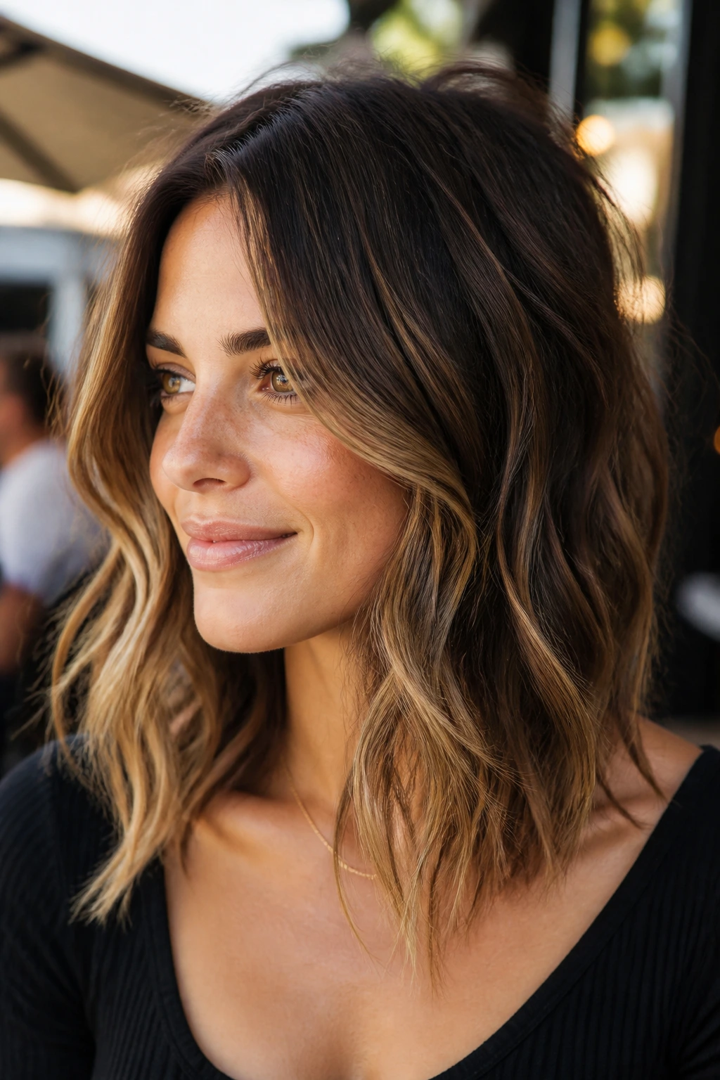Close-up portrait of a real person with textured wavy lob and face-framing layers
