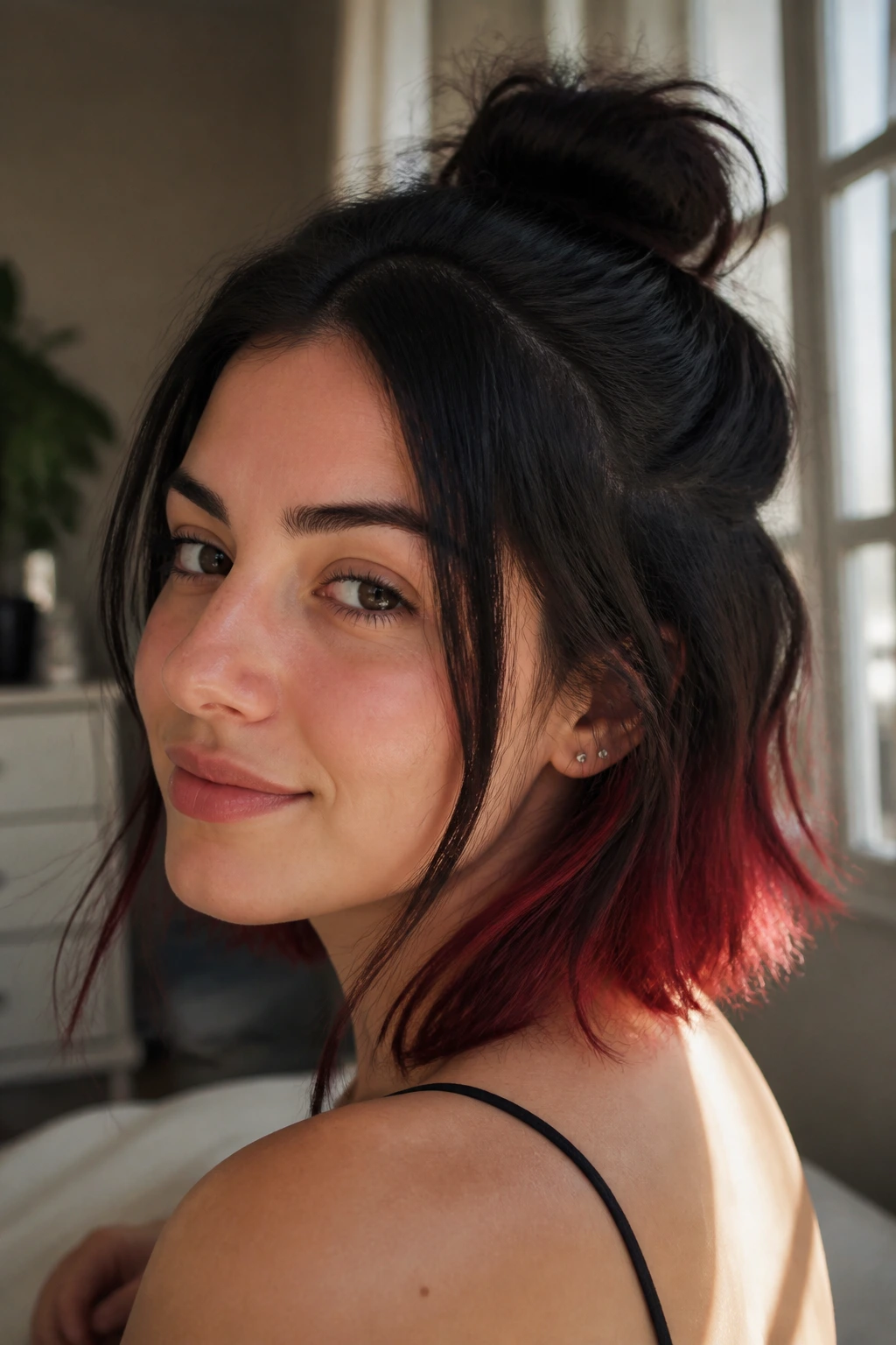 Close-up of a real person with a half-top-knot and face-framing pieces showing red underlayer.