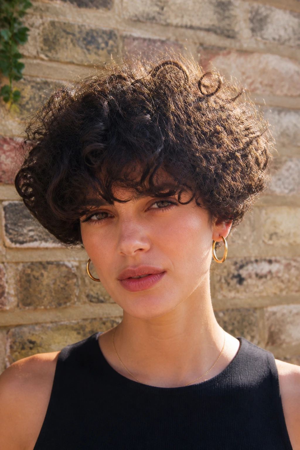 Portrait of a person with voluminous curly bowl cut and heavy bangs