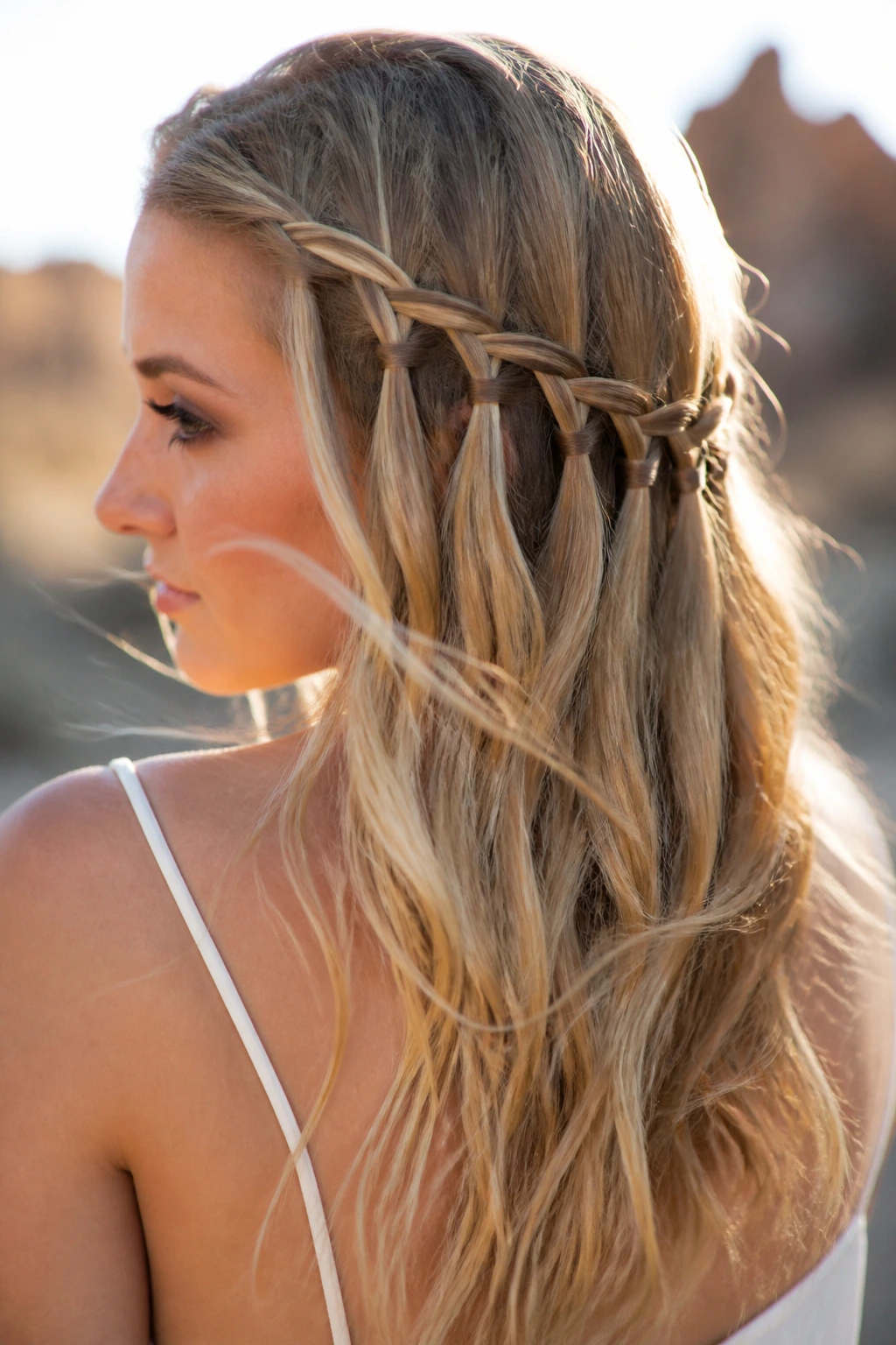 Close-up of a real person wearing a cascading waterfall braid in sunlight