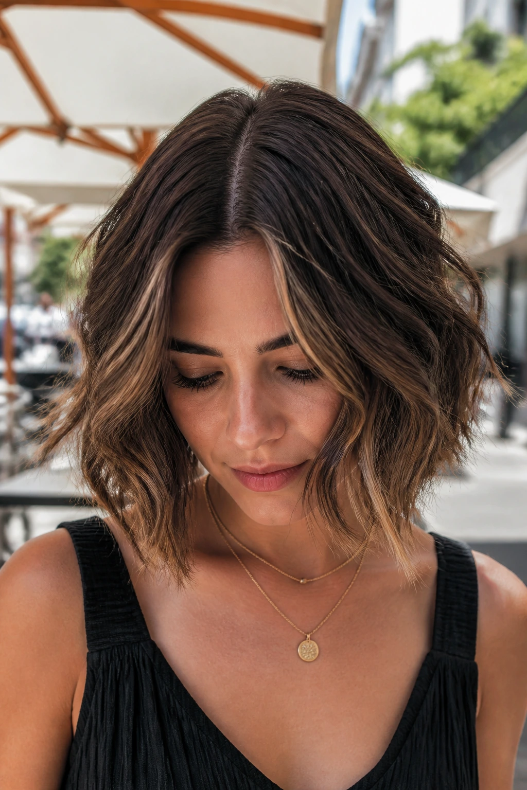 Real woman with center-parted wavy choppy bob in outdoor urban setting