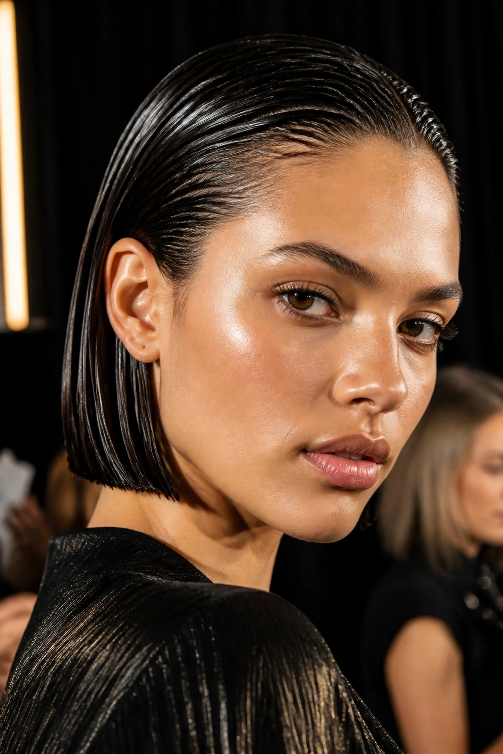 Close-up of a real woman with a glossy wet-look bob backstage at a fashion show