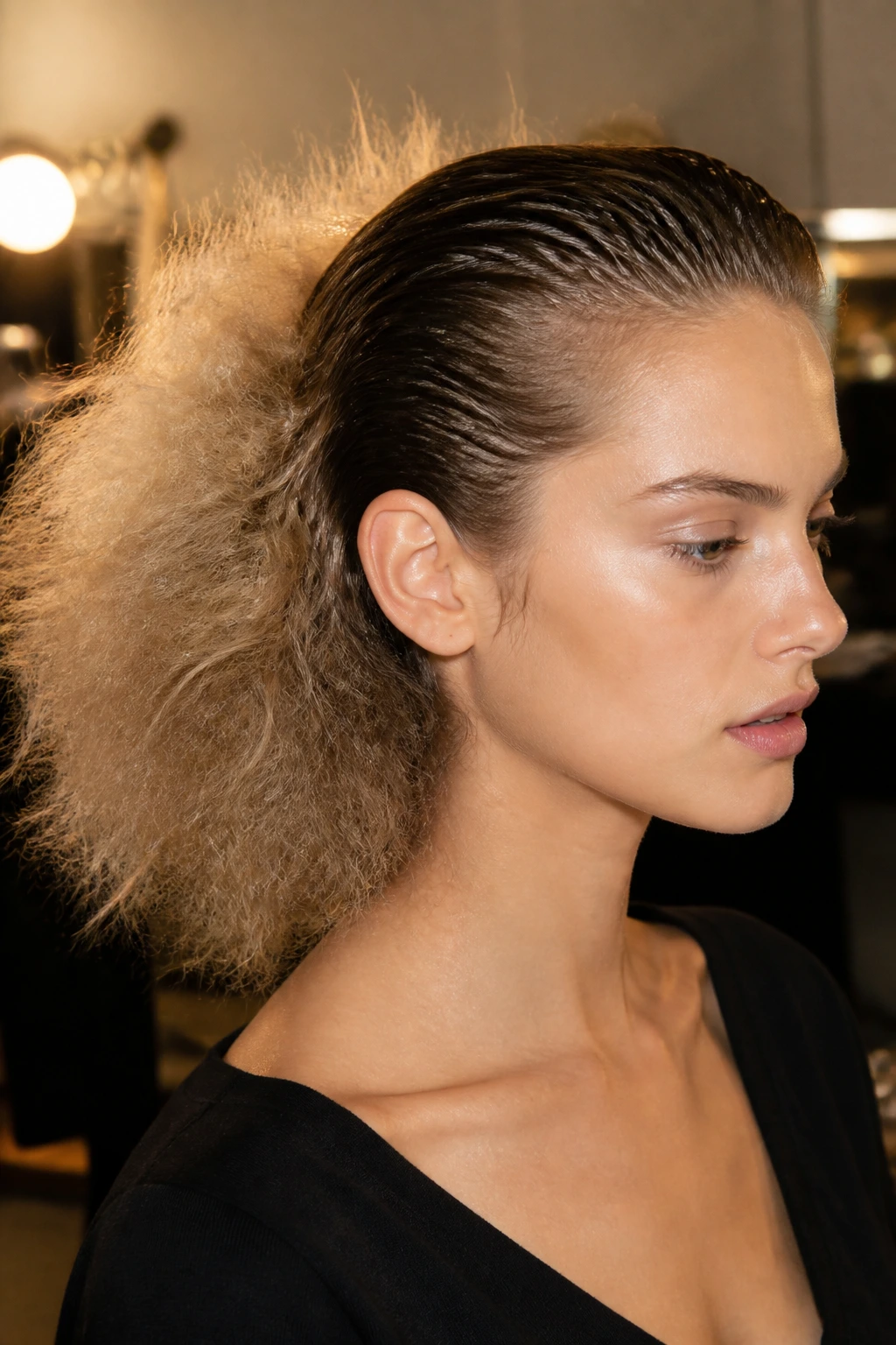 Close-up portrait of a woman with sleek wet-look roots and fluffy ends