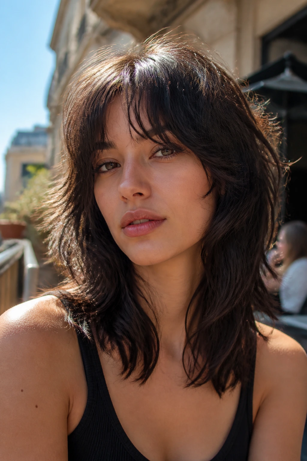 Close-up of a real woman with wavy wolf cut and wispy curtain bangs in golden hour light
