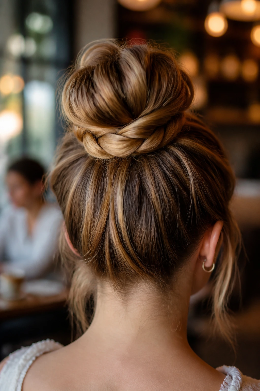Back view close-up of a woman with a wrapped braided bun