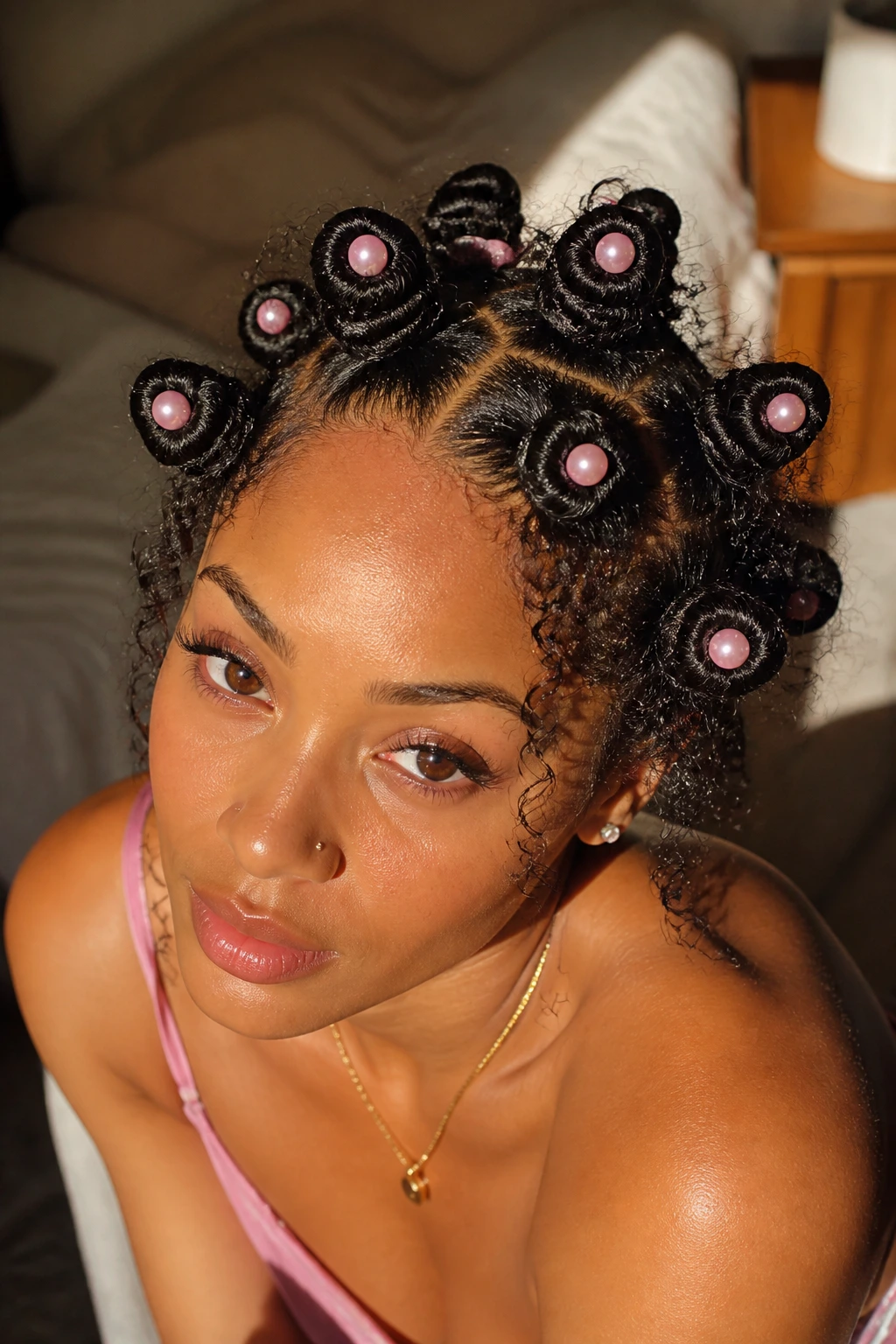 Close-up of a real woman's head with pearl-embellished bantu knots and pink pearls at knot centers.