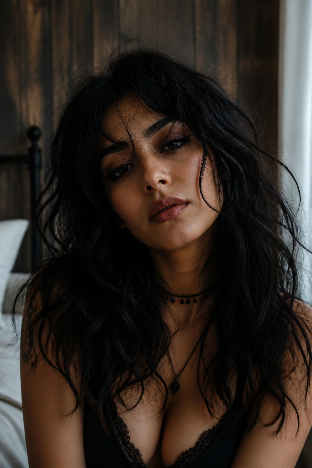 Latina woman with bedhead goth wave hairstyle in moody bedroom