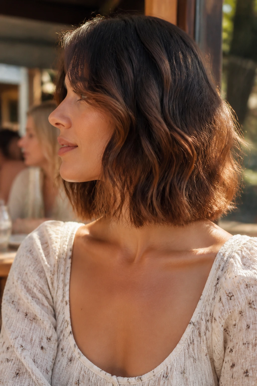Portrait of a real woman with clavicle-grazing wavy cut highlighting neck