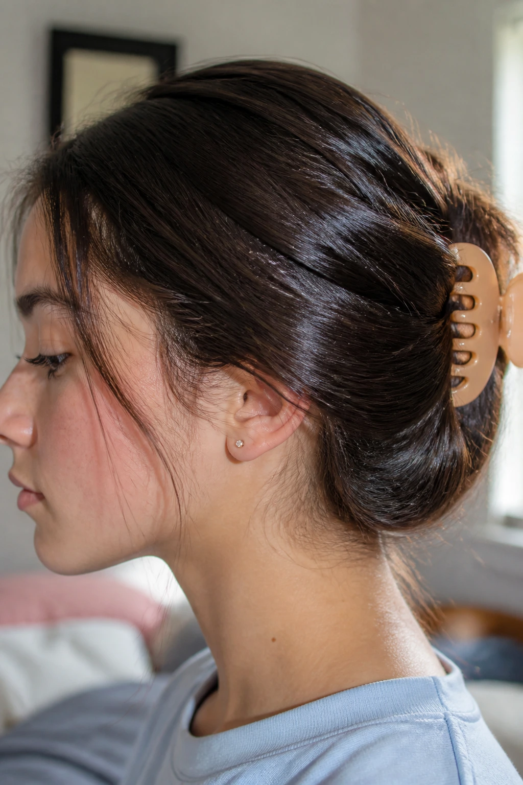 Close-up of real teenage girl with claw clip securing hair and coconut oil shine