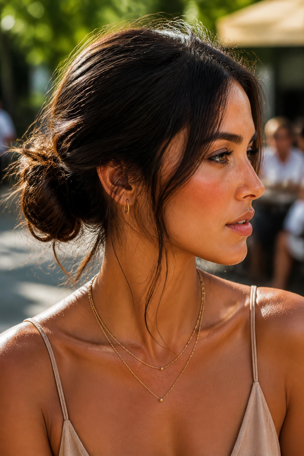 Close-up of a real woman with a messy low bun and wispy strands