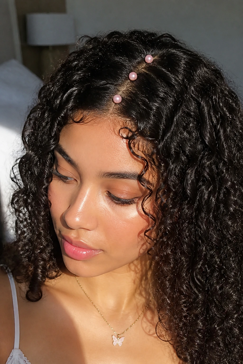 Close-up of a real woman with a pearl-lined middle part in natural morning light