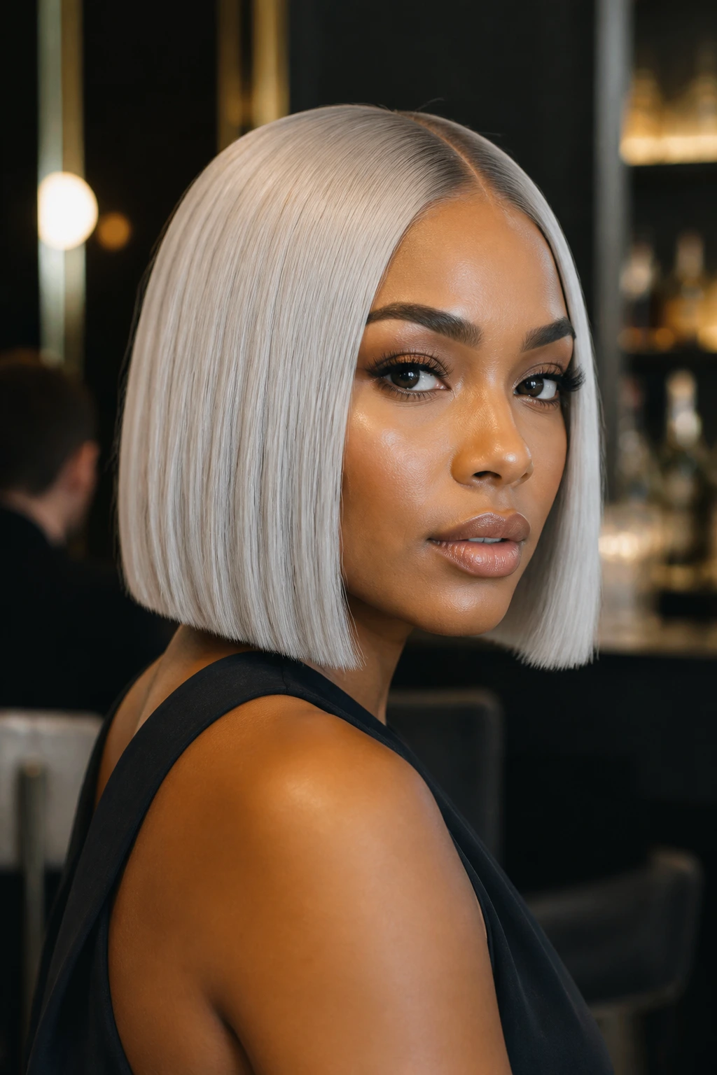 Close-up of a real woman with a platinum silver blunt bob in an upscale cocktail lounge.