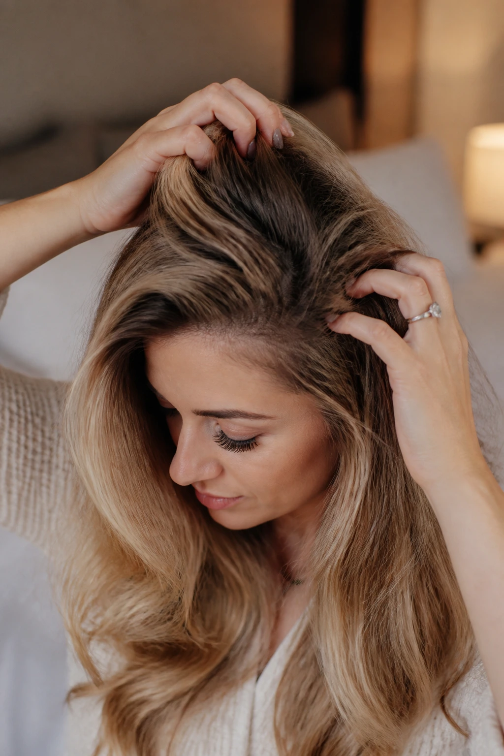 Hands applying texturizing mousse at roots for longer-lasting curls