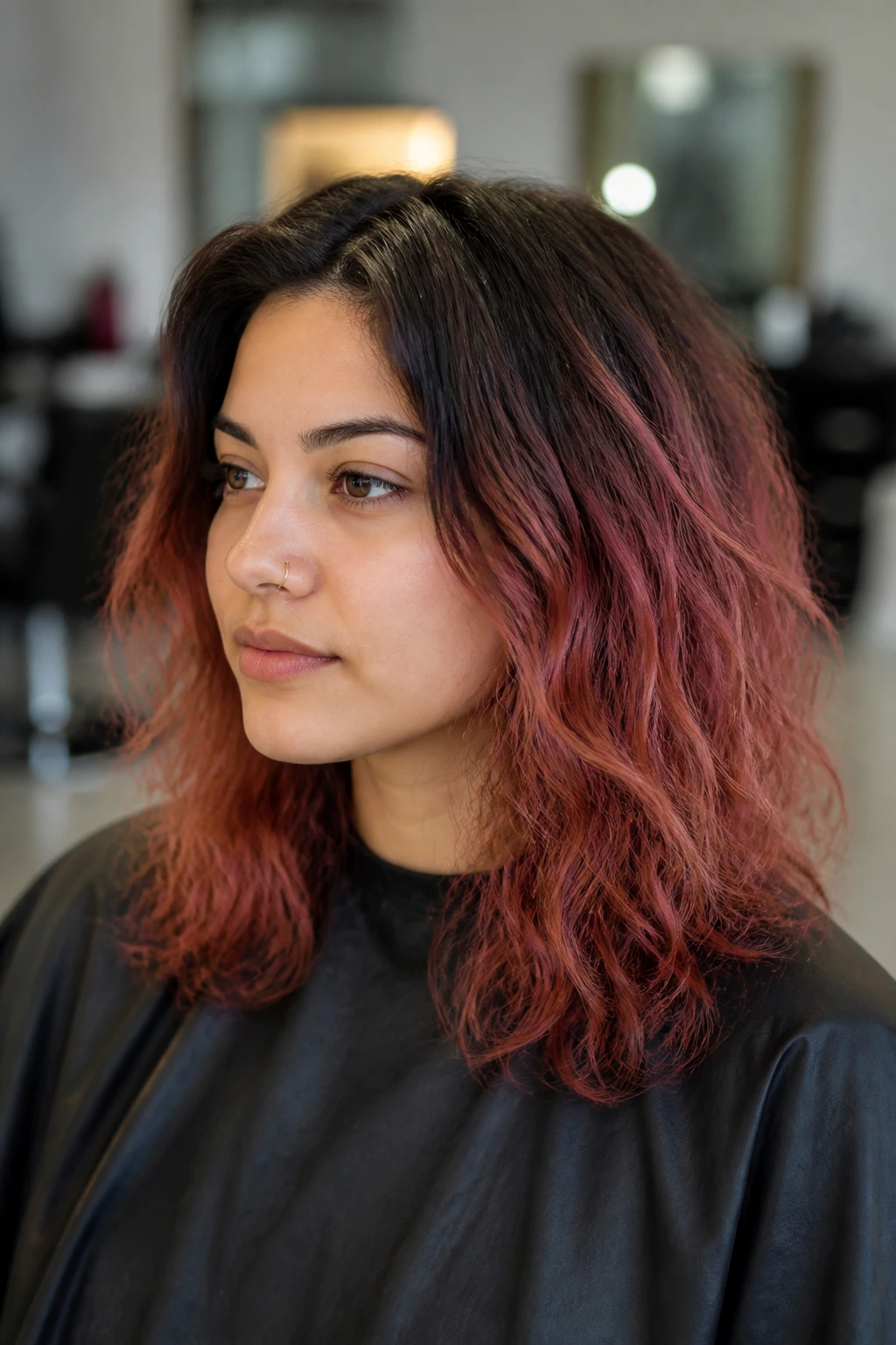 Close-up of a real person showing dark roots transitioning to lighter pink mid-lengths