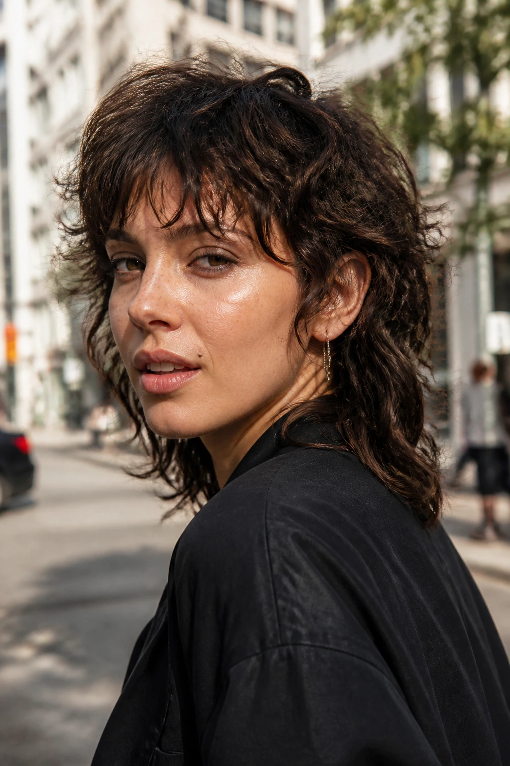 Portrait of a woman with a wavy mullet bob on a sunlit city street