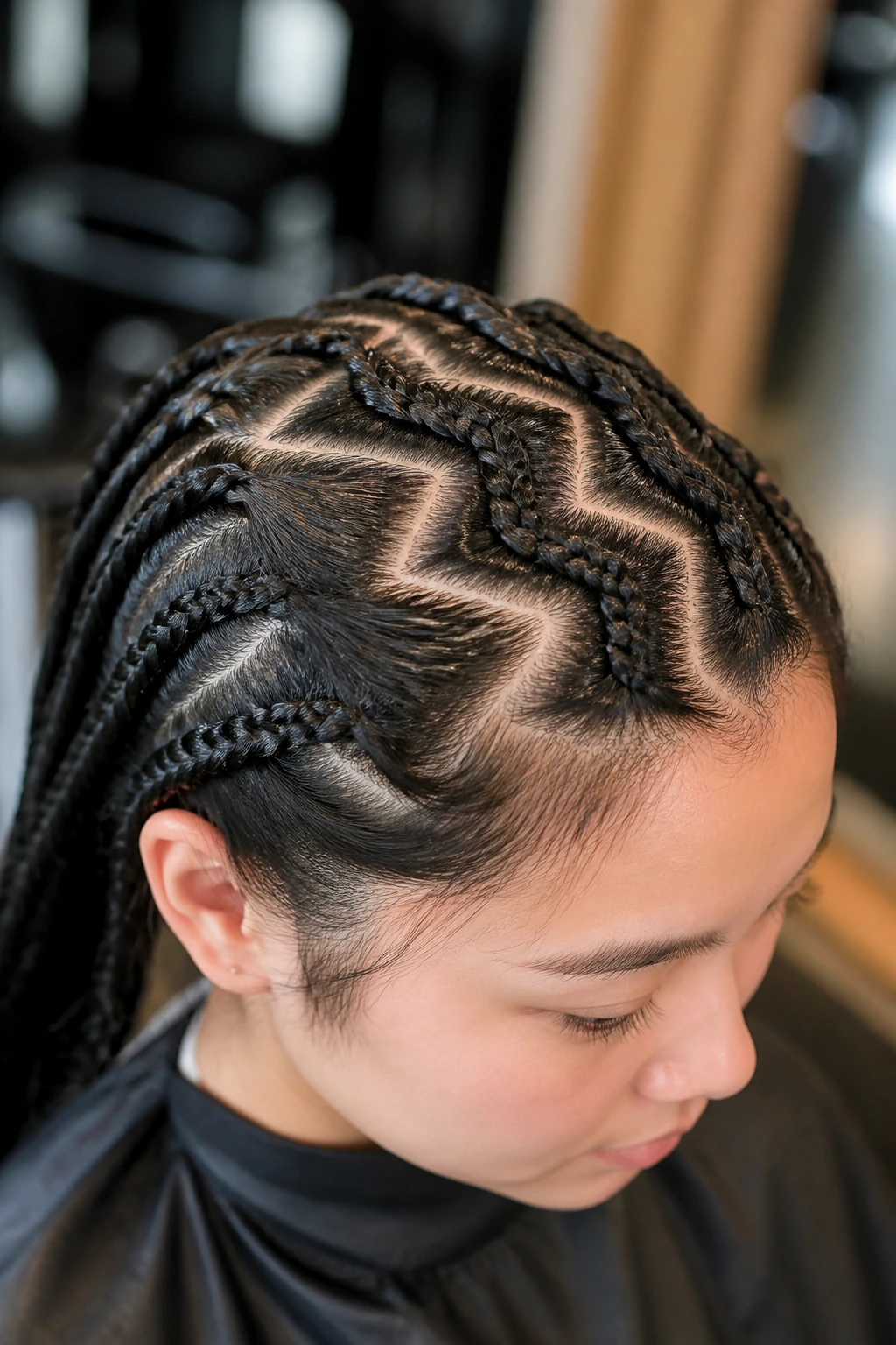 Close-up of a real person with zigzag parting rows in a salon setting